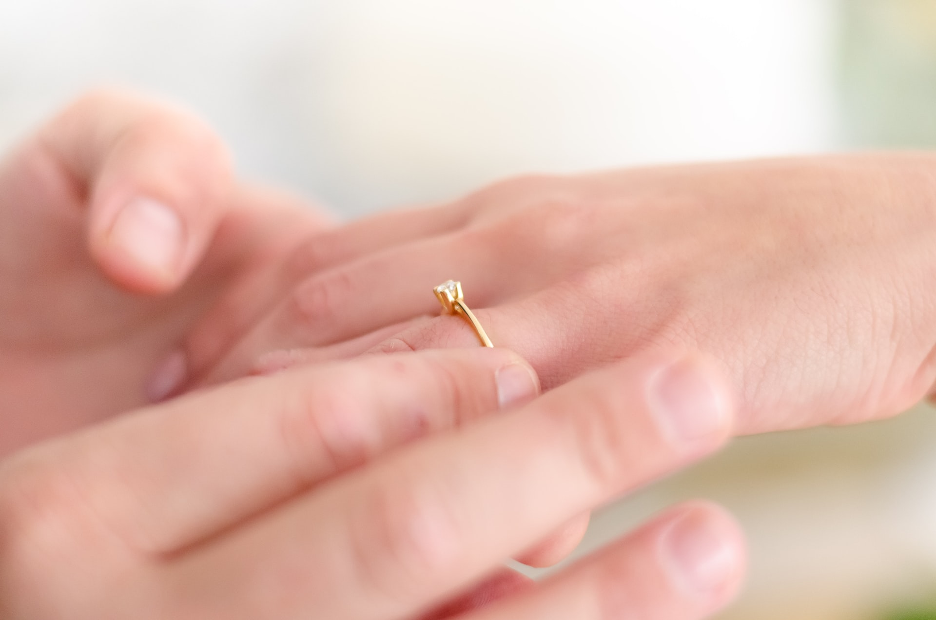 shallow focus photo of person putting gold-colored ring